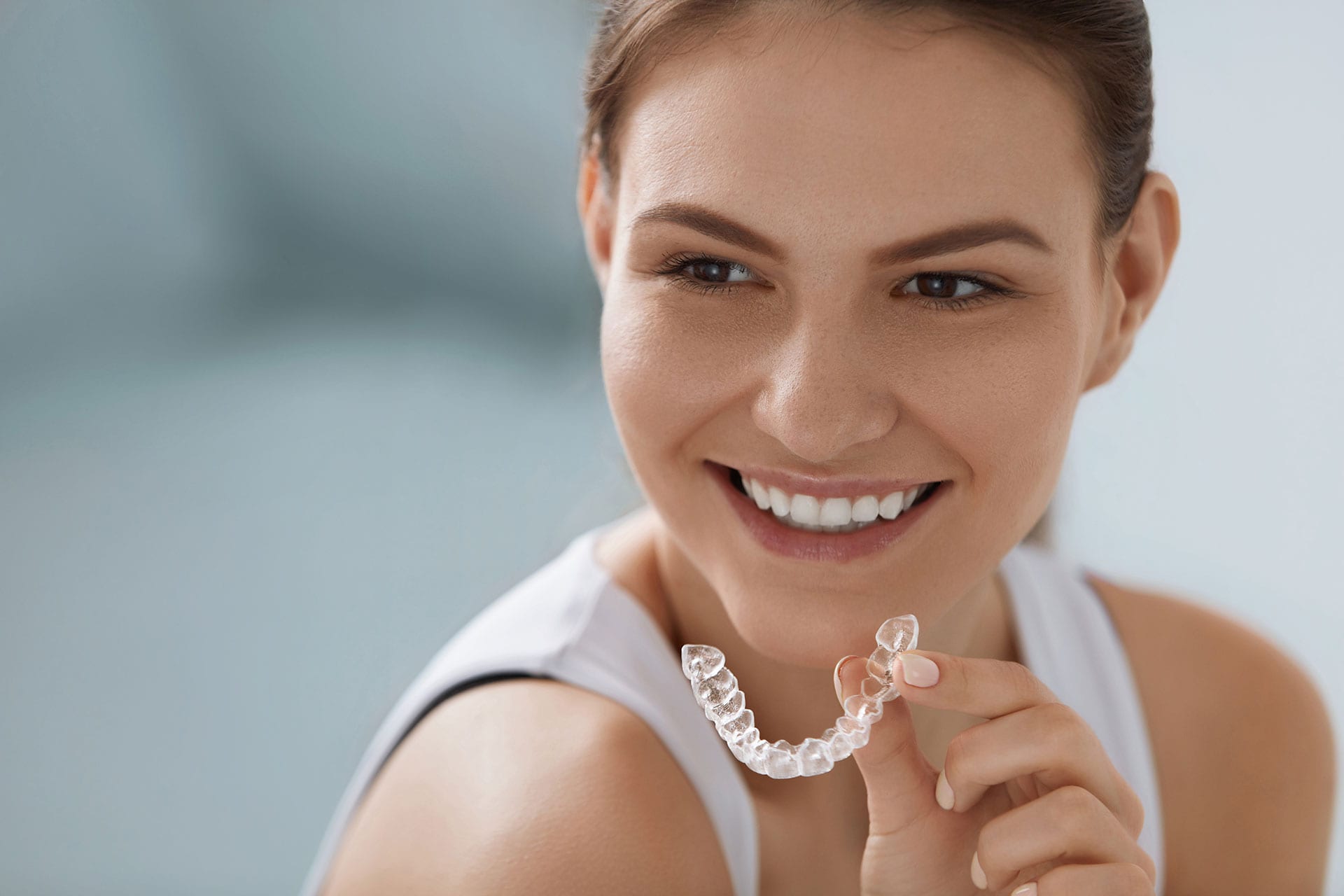 Long Beach patient with aligners in her hand long beach invisalign patient